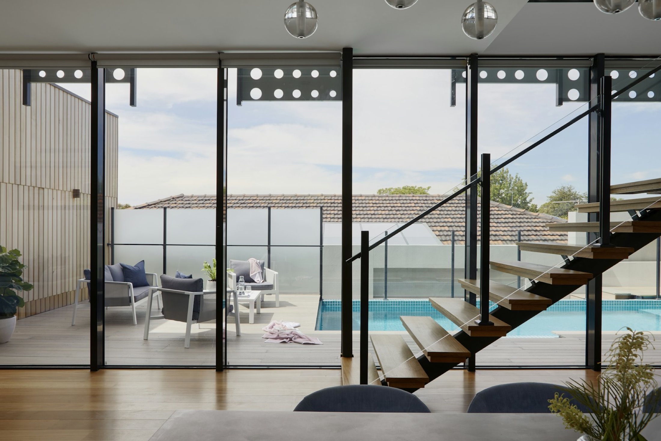 Glass-walled living room with floating stair