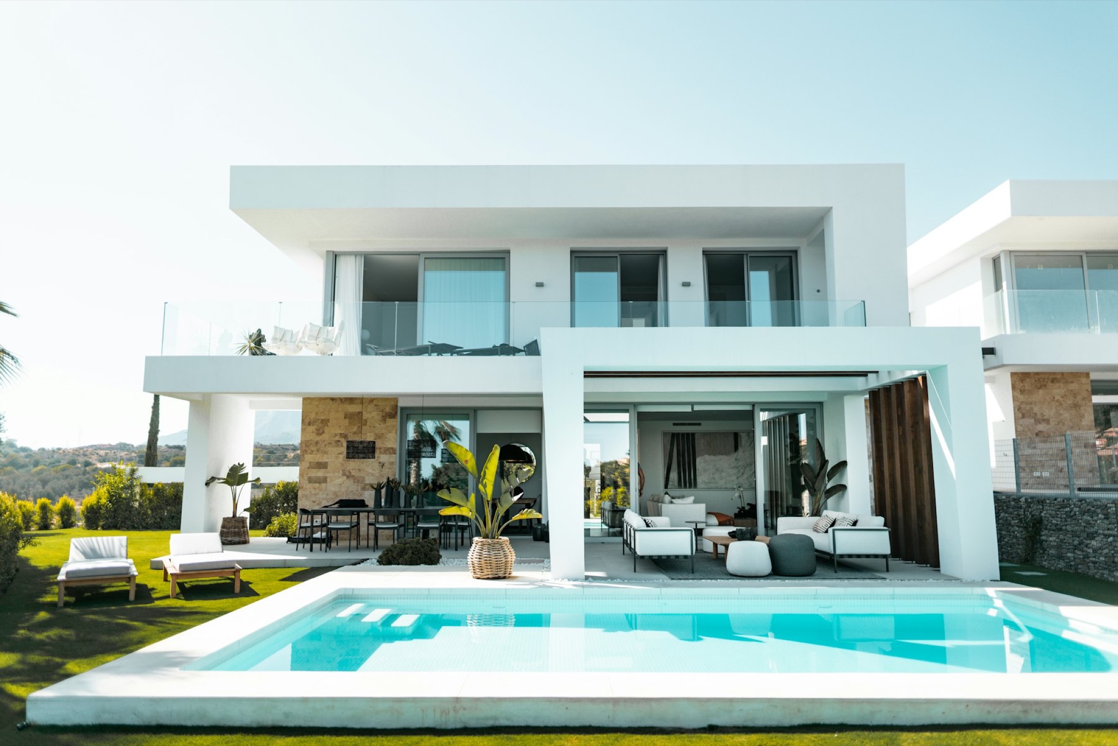 Modern white villa with terraces above a turquoise pool