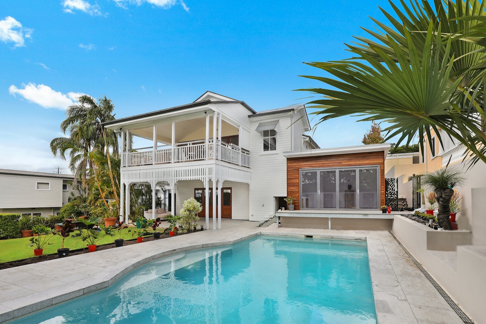 White colonial villa with pool and palms